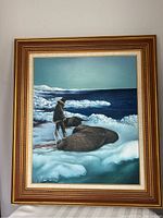 Full view of the framed oil painting depicting the walrus hunter on ice with the ocean and icebergs in background.