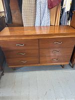 Front view of five-drawer dresser showing wood finish and metal handles.