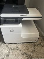 Full front and left side view of HP PageWide Pro MFP 477dw printer showing touchscreen and main body