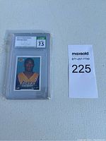 2014-15 Panini Stickers #358 Kobe Bryant graded sticker in protective case with MaxSold lot number card
