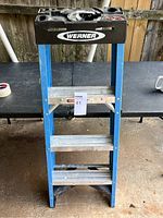 Front view of the Werner 4 foot step ladder showing blue sides, silver steps, black top tool tray, and condition.