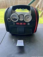 Front view of device showing voltage meter, tire pressure gauge, LED indicator, and control buttons.