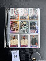 Top view showing binder rings open with nine cards visible in plastic sleeves, including rookies and highlight zone cards.