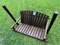 Front and top view of the brand new wooden swing showing the seating area, backrest, armrests, and the metal rings for hanging.