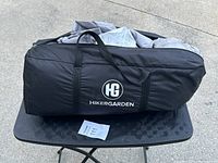 Black HikerGarden branded carrying bag for tent on a black metal table.