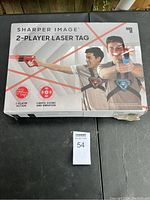 Box of Sharper Image 2-Player Laser Tag showing two players using the toy guns and chest vests for laser tag action.