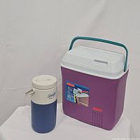 Rubbermaid 20 quart ice chest cooler and Coleman PolyLite cooler jug side by side on white surface against a white backdrop.