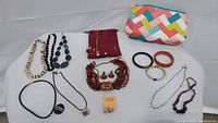 Overall view of all jewelry items and multi-color clutch pouch