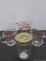 Front view of all four items showing size comparison and labels of Pyrex and Kilner