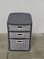 Front view of tote cabinet showing geometric pattern on three drawers