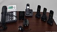Full shot showing all five phones: AT&T speakerphone, Panasonic answering machine phone, and three Panasonic cordless phones.