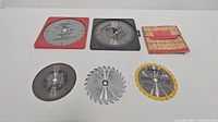 Top view of six various saw blade accessories in different colors and tooth configurations.