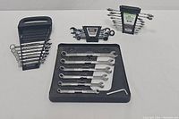 Four wrench sets displayed including 9 pc combination set, 5 pc ratcheting set, and two Craftsman sets arranged on a white background