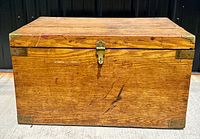 Front view of antique solid oak chest showing lock clasp and brass corner hardware