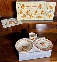 Original box and pamphlet with all three porcelain pieces displayed on top of the box.
