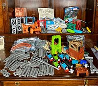 Overview of collection showing numerous toy engines, various track pieces, and play structures arranged on wooden surface.