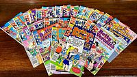 Spread of multiple vintage Betty and Veronica comic books fanned out on a wooden surface