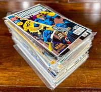 Stack of bagged and boarded vintage comic books with The New Warriors comic visible on top.