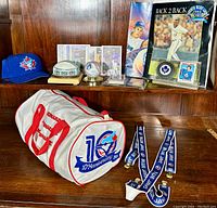 Photo showing multiple Blue Jays items including signed cap, cards, gym bag, suspenders, ceramic skydome, and Wendell Clark puck.