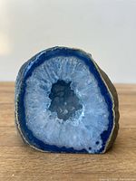 Front view of blue agate geode polished face showing concentric blue and white crystals.