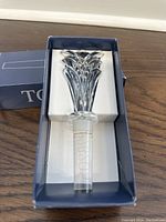 Crystal wine bottle stopper in box showing detailed faceted top and stopper end.