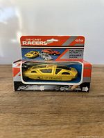 Front view of the die-cast Ferrari toy car in its box, showing details of the yellow car and packaging