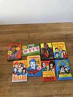 Photo showing nine sealed vintage TV show gum card and sticker packs arranged on a wooden surface