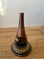 Front view of the vintage wooden eyeglasses display shaped like a nose and face showing carved details and metal-accented base.