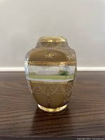 Front view of a vintage Nippon vase with detailed embossing and pastoral hand painted scene under gold leaf