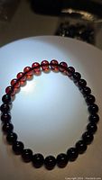 Photo of natural blood amber stretchy bracelet with smooth round deep red translucent beads.