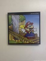 Full front view of 12x12 framed artwork showing Mario on a wooden bridge with a saw blade from Super Mario World (1992) Nintendo themed art