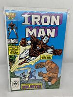 Front cover of Iron Man Issue 206 comic, showing Iron Man in brown armor flying with characters Hawkeye and Mockingbird mentioned.