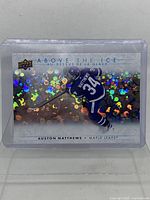 Front view of the Austin Matthews collectible hockey card with holographic background in a plastic sleeve.