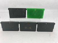 Five used GBA cartridges arranged with backs showing.