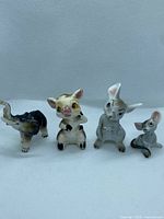 Four small Japanese bone china animal figurines displayed together, showing size and details.