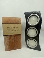 Black wooden candle holder with three white tealight candles