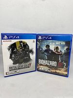 Front covers of Metal Gear Solid V Ground Zeroes and Biohazard RE2 PS4 games showing artwork and branding.