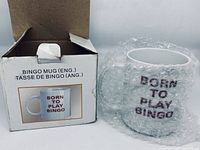 Photo showing the mug wrapped in bubble wrap next to the original box displaying the mug image and text.