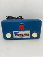 Front view of the blue Atari 2600 Track & Field joystick controller showing three buttons and the game logo label.