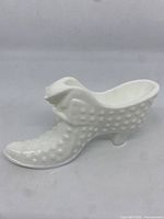 Front and side view of the white milk glass hobnail Puss in Boot figurine, showing detailed textured surface and boot shape.