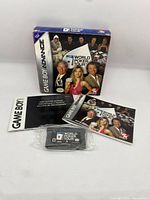 Photo showing the Game Boy Advance cartridge, original box, and two manuals including the Game Boy Advance instructions and World Poker Tour manual.