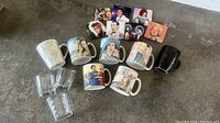 Photo showing all drinking glasses, mugs with vintage images, black plain mug, cactus mug, and icon coasters arranged on floor.