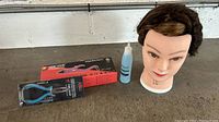 Mannequin head, GBB Hair Extension Iron box, GBB Hair Keratin Bond Remover bottle, and GBB Extension Plier in packaging on table