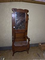Full view of the wooden hall tree showing seat, mirror, and hanging pegs with visible wear and white mildew on mirror glass.