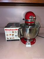 Front view of Empire Red KitchenAid stand mixer with stainless bowl and slicer/shredder box
