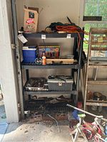 Full view of the black plastic utility shelf unit with various items on shelves removed for sale as empty unit.