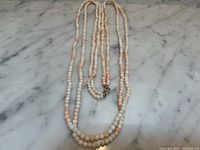 Full view of necklace laid out on marble surface