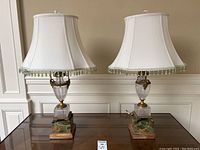 Two matching table lamps on a table against paneled wall, showing overall design
