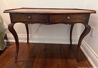 Front elevation showing two drawers with brass knobs and overall desk silhouette