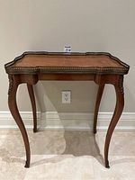 Full front view of the table showing overall shape, cabriole legs and gallery edge